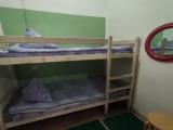 Спальное место на двухъярусной кровати в общем номере для мужчин и женщин