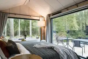 Дом с ванной у панорамного окна в хвойном лесу by Lynwood