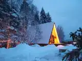 Лесной домик a-frame с террасой на холме, среди высоченных елей и берез