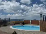 Апартаменты с теплым бассейном и видом на море и горы.